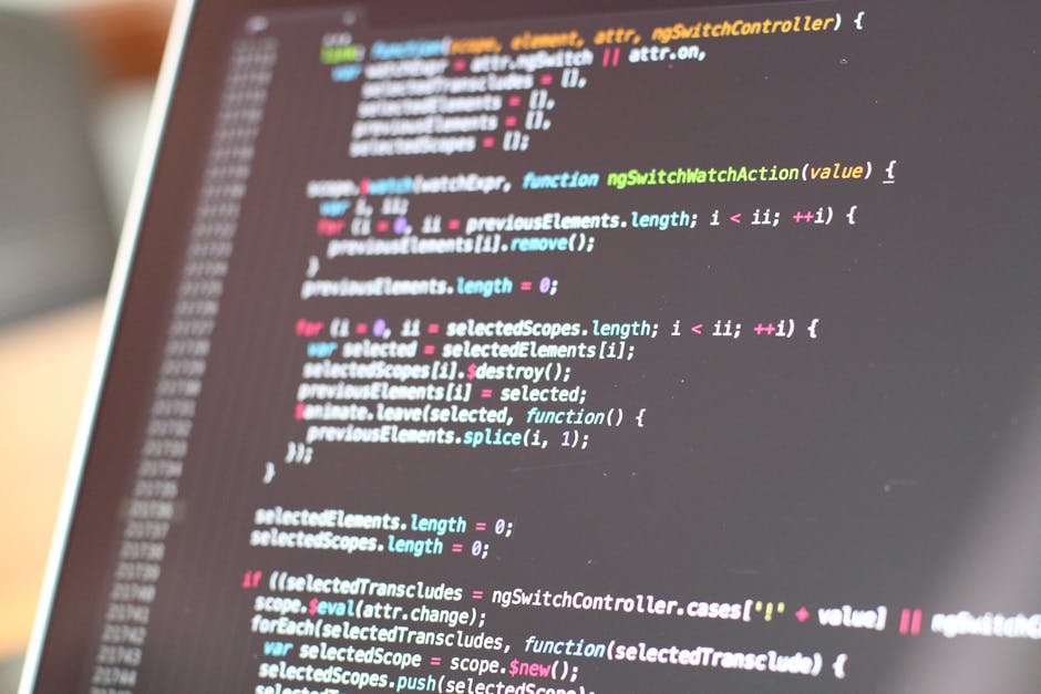 A computer screen displaying a close-up of a web browser window with lines of HTML and CSS code in various colors, including red, green, blue, and purple, on a dark background. The code is slightly bl